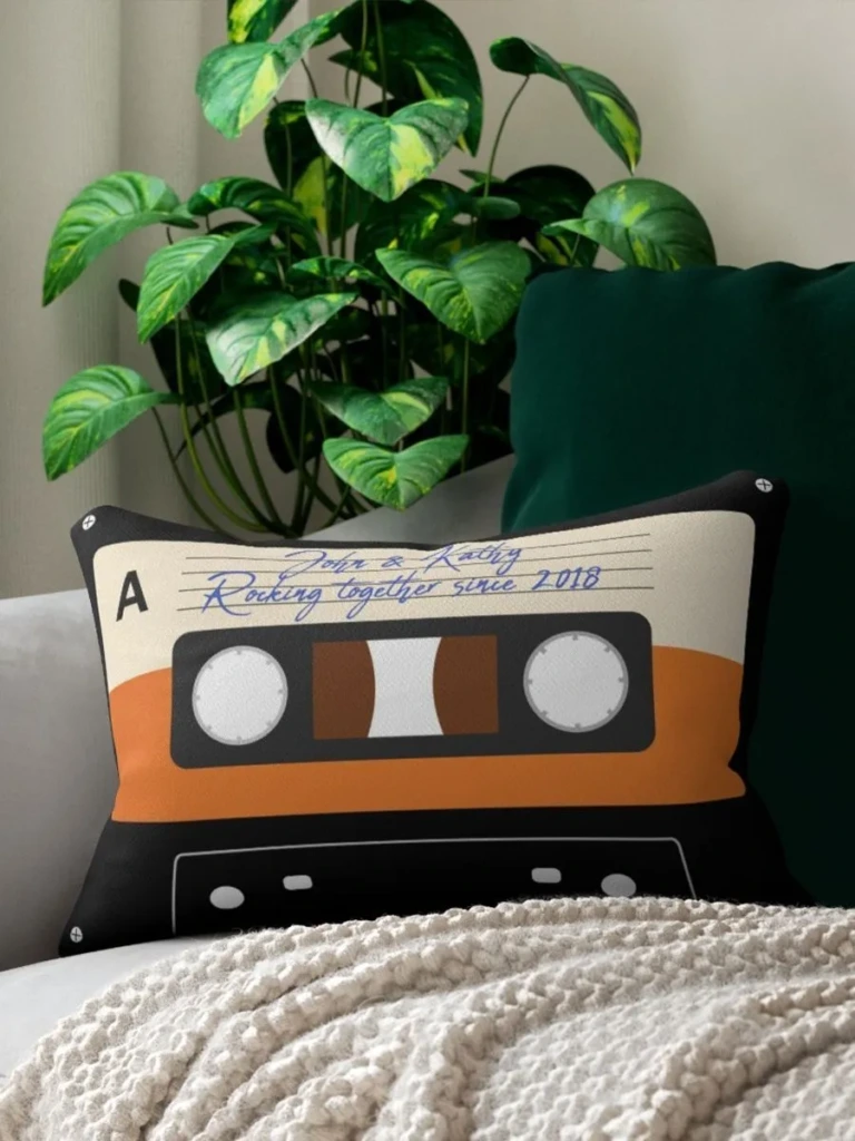 Personalized pillow with colorful cassette tape design print and custom text displayed on a couch.