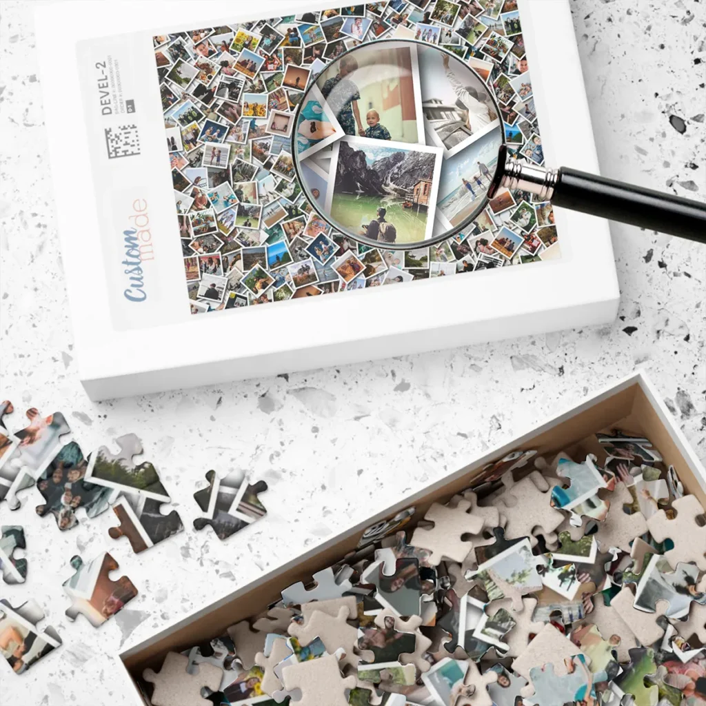 Custom photo collage jigsaw puzzle on table with magnifying glass highlighting personalized design and loose puzzle pieces inside and outside the accompanying box.
